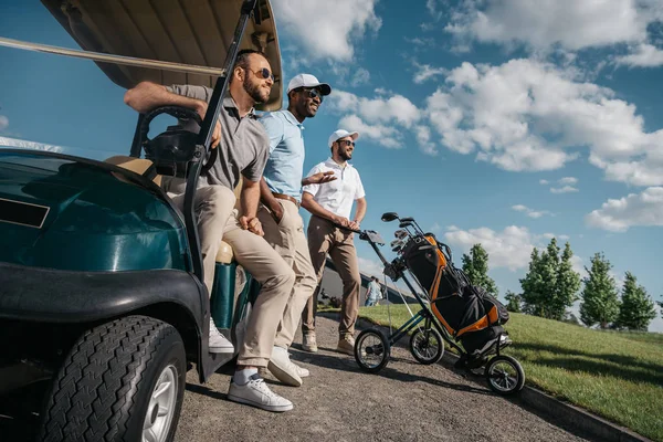 Homens de pé perto do carrinho de golfe — Fotografia de Stock