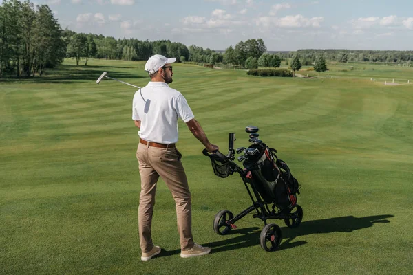 Игрок в гольф стоит на зеленом поле — стоковое фото