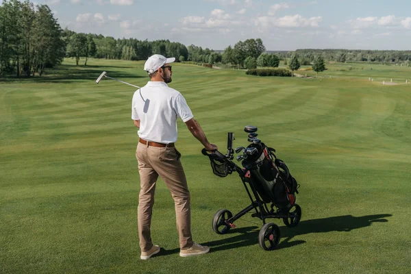 Jogador de golfe em pé no campo verde — Fotografia de Stock