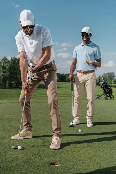 Golfer steckt Ball in Loch — Stockfoto