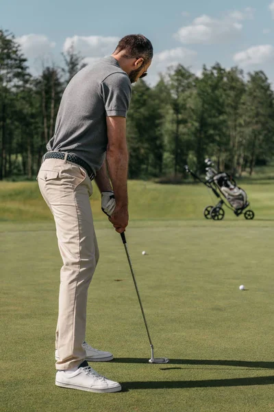 Jeune homme occasionnel jouer au golf — Photo de stock