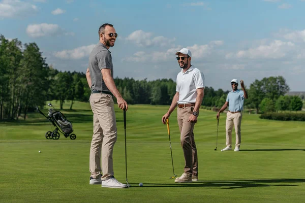 Amis souriants jouer au golf — Photo de stock
