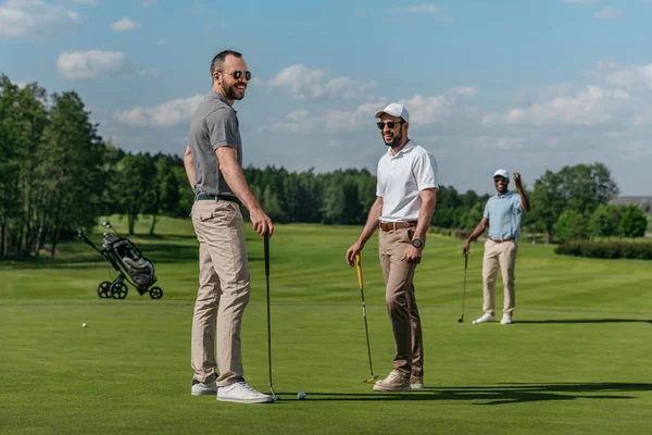 Amigos sorridentes jogando golfe — Fotografia de Stock