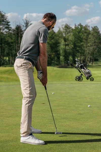 Young casual man playing golf — Stock Photo