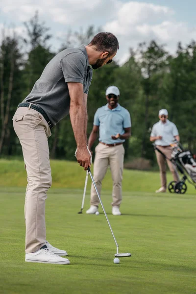 Golfer aiming to hit ball with club — Stock Photo