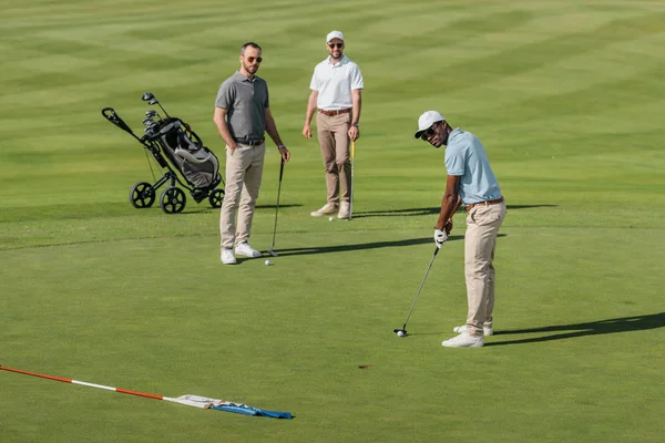 African american golfer take a shot — Stock Photo