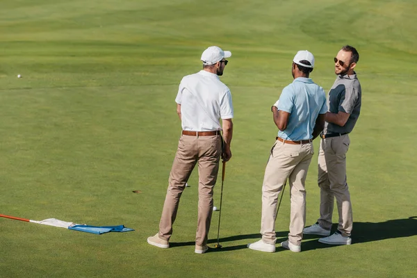 Golfistas profesionales hablando en campo verde - foto de stock