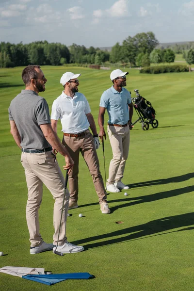 Мультиэтнические игроки в гольф смотрят в сторону — стоковое фото
