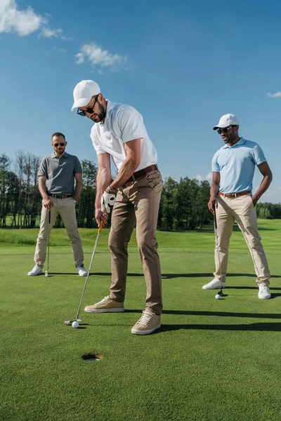 Golfista colocando bola no buraco — Fotografia de Stock