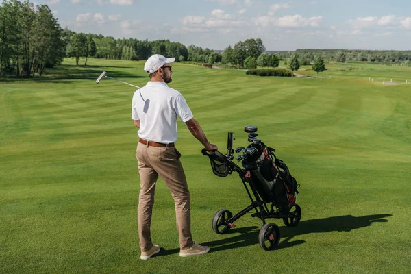 Jogador de golfe em pé no campo verde — Fotografia de Stock