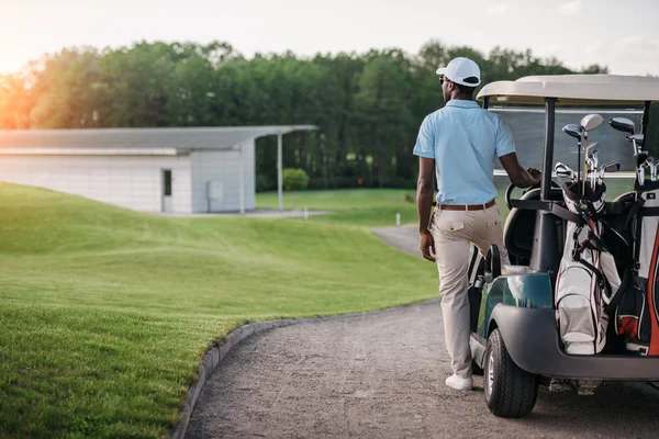Golfista in piedi vicino golf cart — Foto stock