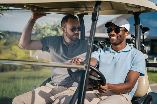 Homens montando carrinho de golfe — Fotografia de Stock