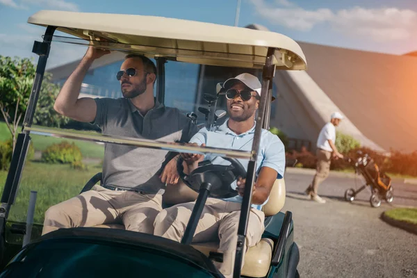 Hommes équitation golf chariot — Photo de stock