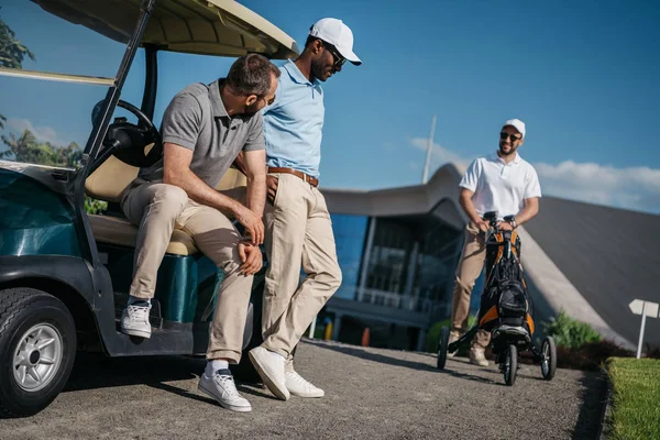 Homens de pé perto do carrinho de golfe — Fotografia de Stock