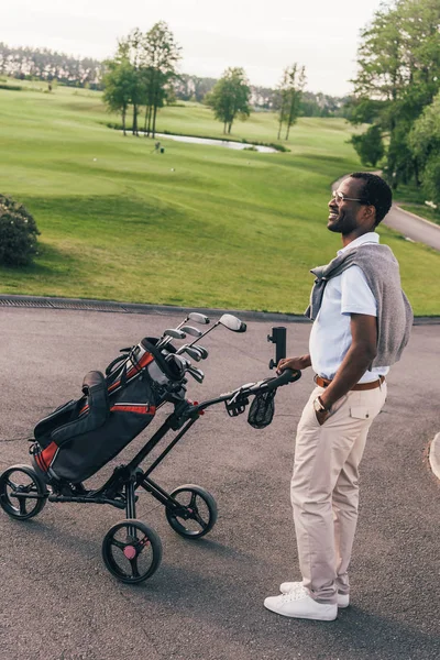 Hombre con palos de golf en bolsa - foto de stock