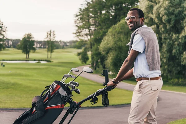 Homem com tacos de golfe no saco — Fotografia de Stock