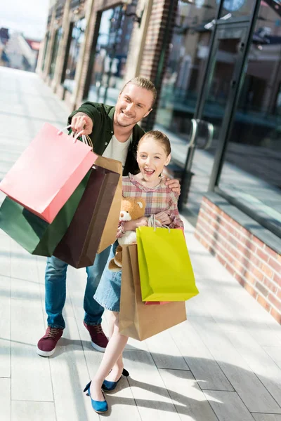 Padre e hija sosteniendo bolsas de compras - foto de stock
