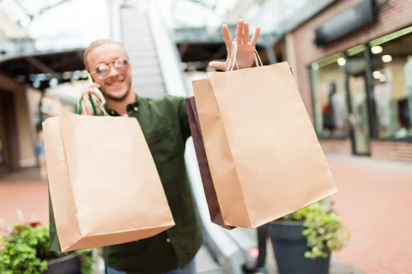 Hombre con bolsas de compras en el centro comercial - foto de stock