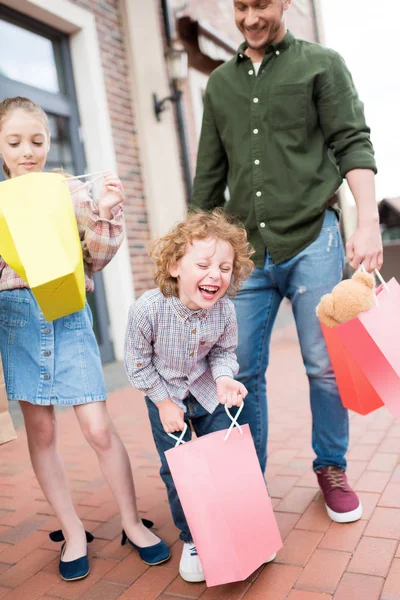 Family with shopping bags on street — Stock Photo