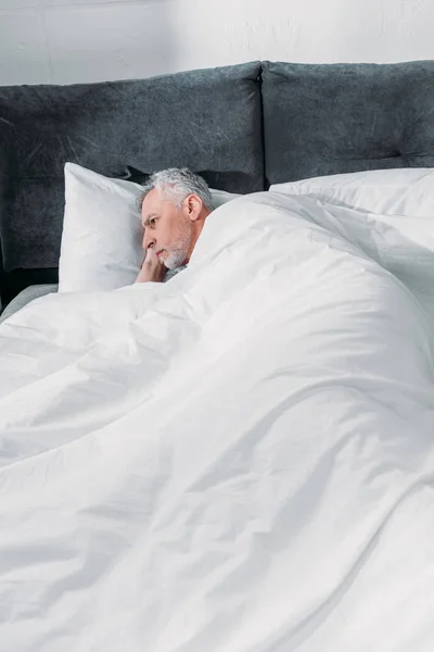 Homme couché au lit — Photo de stock