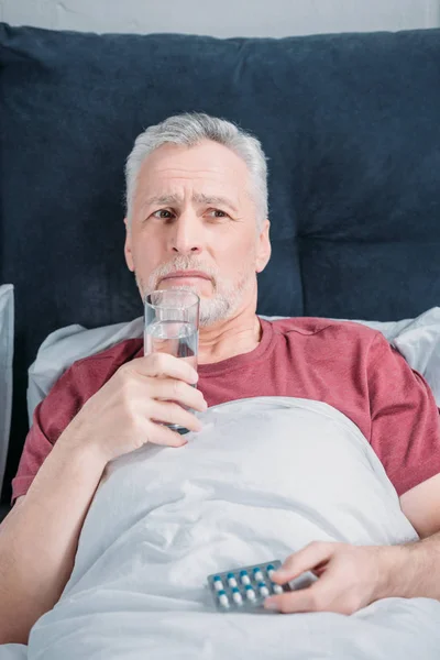 Hombre enfermo con medicamentos - foto de stock