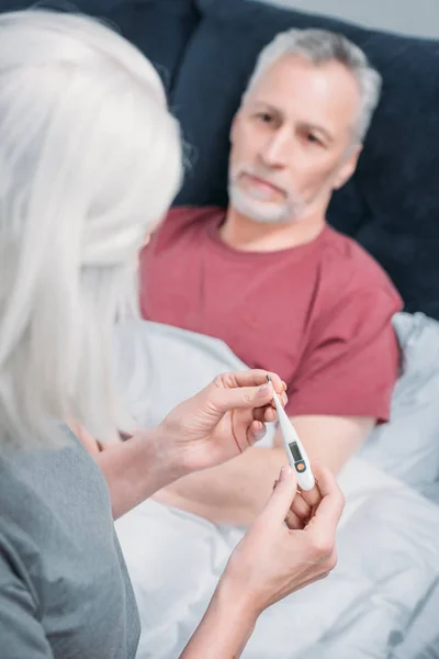 Mujer cuidando de su marido - foto de stock