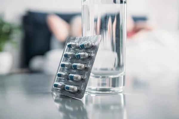 Vaso de agua y medicamentos - foto de stock