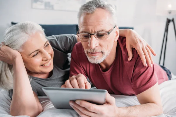 Pareja con la tableta en casa - foto de stock