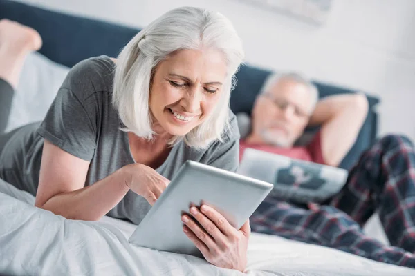 Femme avec comprimé au lit — Photo de stock