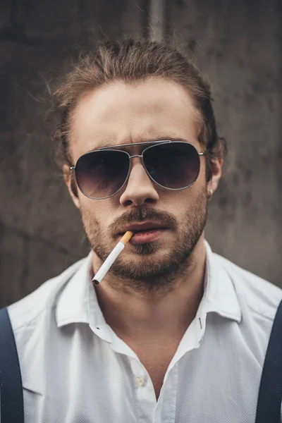 Jeune homme élégant fumant — Photo de stock