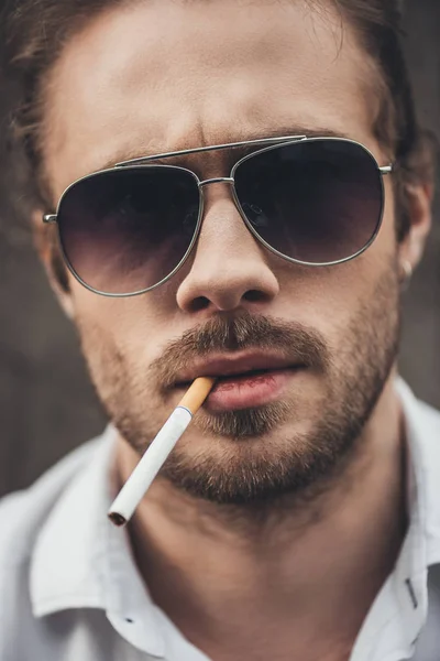 Jeune homme élégant fumant — Photo de stock