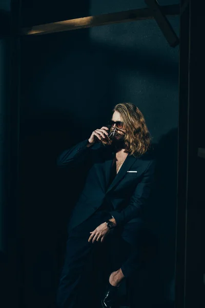 Hombre de traje bebiendo whisky - foto de stock