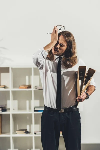 Tired businessman with folders — Stock Photo