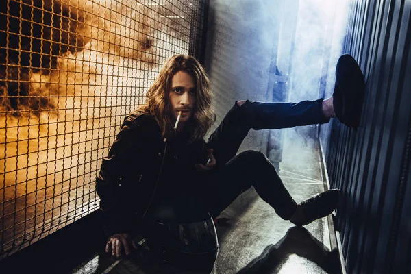 Stylish long haired man with cigarette — Stock Photo