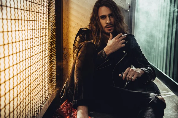 Élégant homme aux cheveux longs avec cigarette — Photo de stock