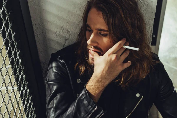 Stylish long haired man with cigarette — Stock Photo