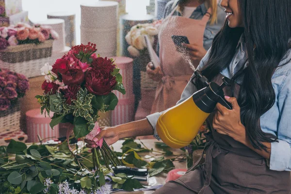 Florist spraying flowers — Stock Photo