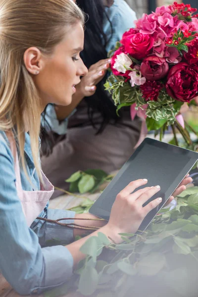 Floristería usando tableta digital - foto de stock