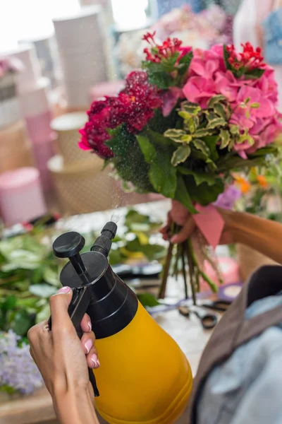 Florist spraying flowers — Stock Photo