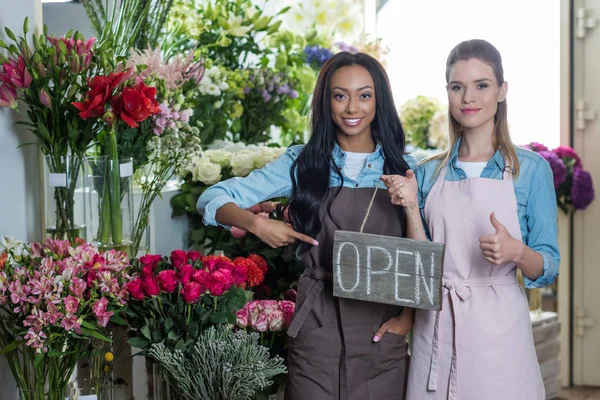 Multiethnic florists with open sign — Stock Photo