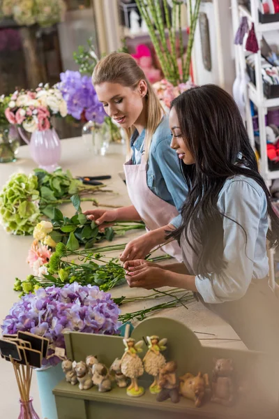 Багатоетнічні флористи в квітковому магазині — стокове фото