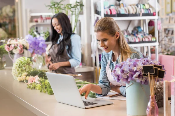 Floristería usando portátil - foto de stock