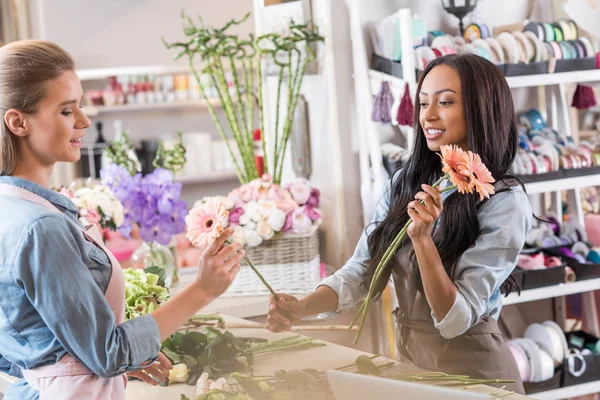 Floristas multiétnicos en floristería - foto de stock
