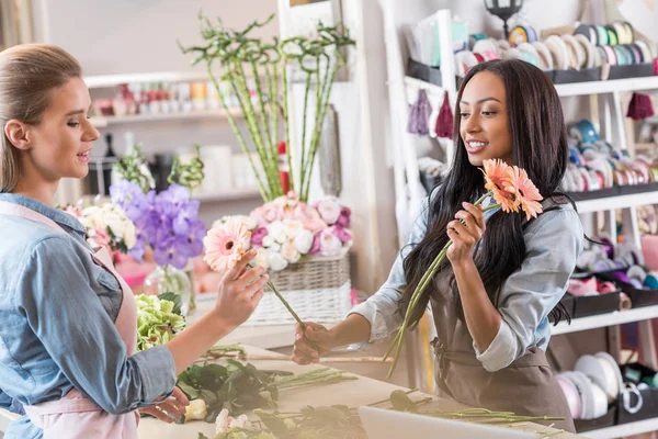 Floristas multiétnicos em florista — Fotografia de Stock