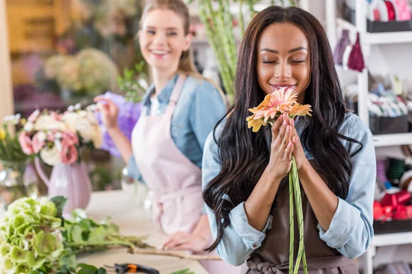 Floristas multiétnicos en floristería - foto de stock