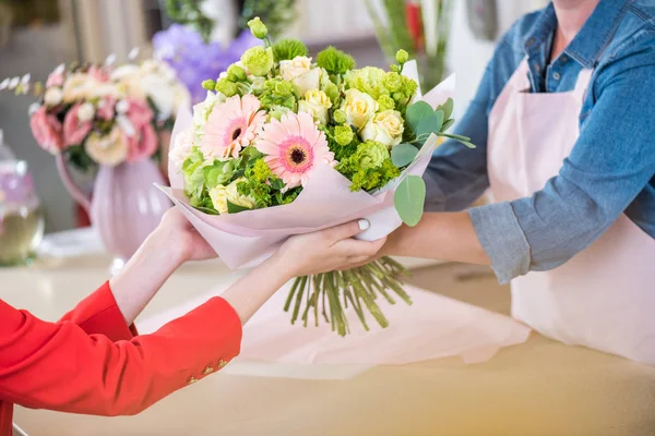 Fiorista dando bouquet al cliente — Foto stock