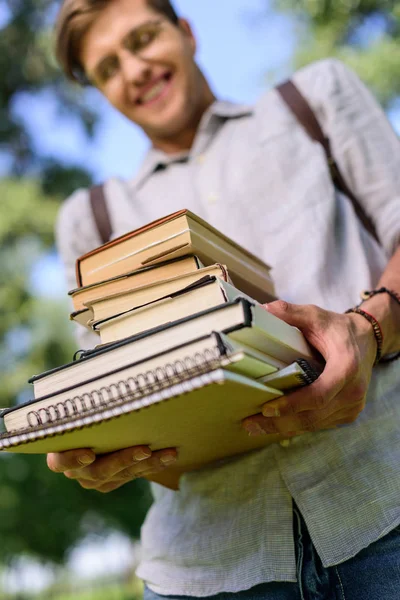 Jovem com pilha de livros — Fotografia de Stock