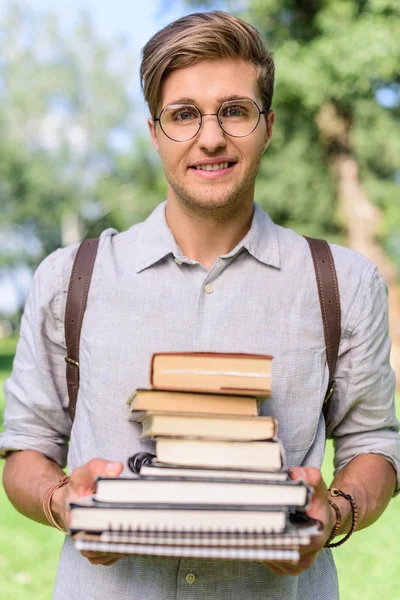 Joven con un montón de libros - foto de stock