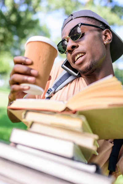 Jovem com pilha de livros — Fotografia de Stock