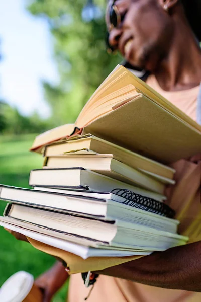 Jovem com pilha de livros — Fotografia de Stock